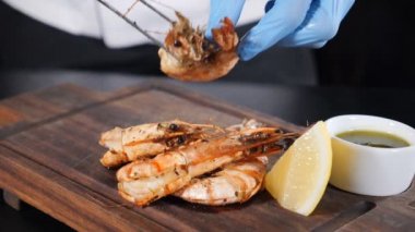 Profesyonel aşçı, bol yağda kızartılmış kral karidesleriyle servis yapıyor. Yan görüş. Restoran yemeği konsepti. Ağır çekim. Tam Hd