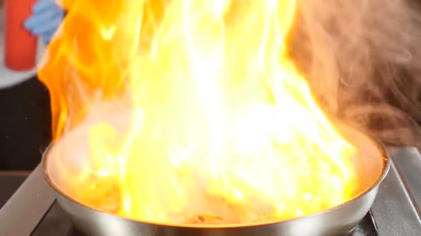 Närbild bilder av kock matlagning huvudrätt bankett. Förbereder tigerräkor med eld i slow motion. flambe stil på pan i hotellets restaurang. Måltidskoncept. hd-video — Stockvideo