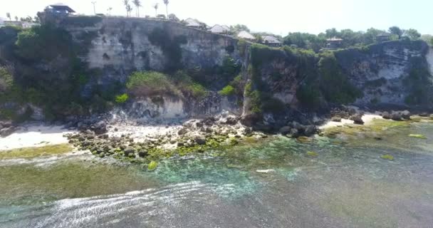 Drone images de côtes rocheuses, océan pittoresque avec des vagues éclaboussantes. Bonjour à Bali, Indonésie. plage tropicale Bali avec plage azur, montagnes rocheuses et l'eau de mer claire de l'océan Indien à la journée ensoleillée — Video