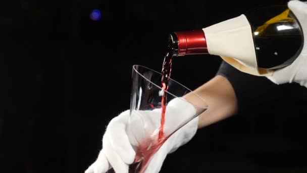 Concetto di cantina. Vino rosso versando in decanter vino su sfondo scuro. Primo piano del collo della bottiglia di vino rosso versato nel decanter. Al rallentatore. Degustazione. hd completo — Video Stock