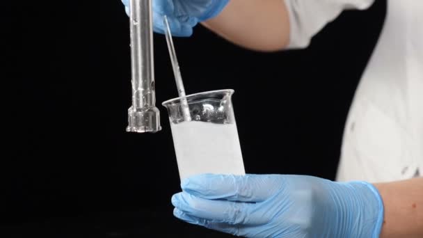 Lab expert making chemical experiment. Close-up of specialist in gloves mixing ingredients in glass tube in laboratory conditions. Slow motion. Full hd — 비디오