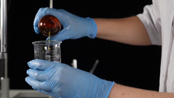 Lab expert making chemical experiment. Close-up of specialist in gloves mixing ingredients in glass tube in laboratory conditions. Slow motion. Full hd — 비디오