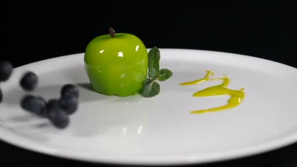 In Zeitlupe werden Blaubeeren auf einen weißen Teller mit köstlichem Dessert geworfen. Konditor, der Süßes im Restaurant serviert. Food-Video. Voll hd — Stockvideo