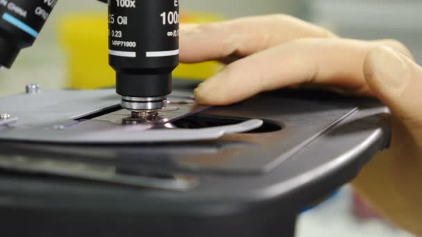 Steril, parlak laboratuvar odasındaki modern mikroskop hücre örneklerini analiz ediyor. Mikro biyoloji ve kimya alanındaki çığır açan bilimsel keşifler icatlara öncülük ediyor. 4k görüntü — Stok video