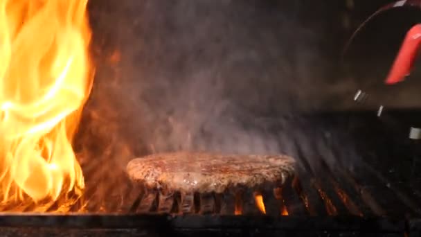 スローモーションでバーガーのシェフの料理肉。レストランでハンバーガー肉を焼く。シェフの手は熱いグリルと油で油で油をミンチ肉バーガーを準備します。フルHD — ストック動画