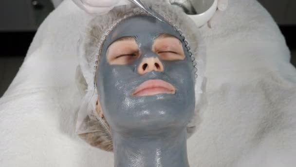 Kadın müşterinin yüz güzelliği tedavisinin üst görüntüsü. Güzellik salonunda yüz yüze maske takmak. Yüz maskeli genç bir kadın için spa terapisi. İşteki güzellik uzmanı. 4k video — Stok video