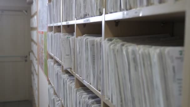 Medische dossiers. catalogus in de kliniek. Gezondheidskliniek. Ouderwetse medische kaarten op planken in het ziekenhuis. Patiëntenkaart Registreren in tandartspraktijk. Ziektekostenverzekeringsmap in archiefbestanden, 4k-beeldmateriaal — Stockvideo