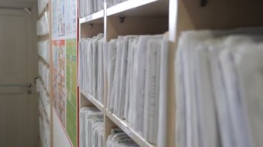 Hasta kartı, dişçi ofisinde. Arşiv dosyalarındaki sağlık sigortası klasörü, tıbbi kayıtlar. Klinikteki katalog. Sağlık hizmetleri kliniği. Hastanedeki raflarda eski moda tıbbi kartlar. 4k görüntü