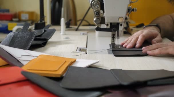 Couture de produits en cuir bricolage fait à la main, sac, entreprise, artisanat. Petite fabrication privée de cuir. Atelier de fabrication de sac en cuir sculpté - artisan coud des pièces de sac à main en cuir sur machine à coudre. 4k — Video