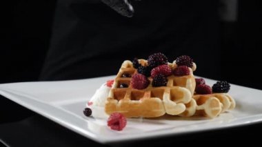 Delicious holiday wafers with raspberries and blueberries served on white plate. Slow motion food video. Freshly baked food, lined with blueberries and ice-cream, juicy berries for breakfast. Food