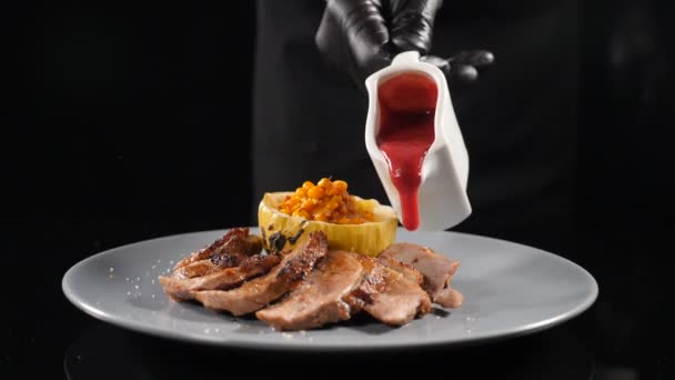 Restaurant meat dish cooking. Fine cuisine. Pouring with red cowberry sauce on sliced meat served on plate in slow motion. Shot in hd — Stok video