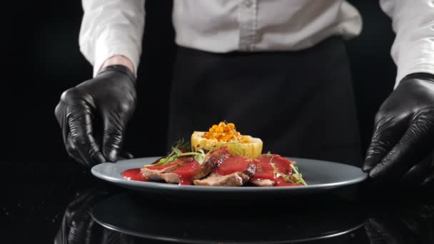 Restaurant food concept. chef presenting his food plate in kitchen. Close up. Restaurant food cooking and serving. Chef hands holding plate and putting on table. hd — 图库视频影像