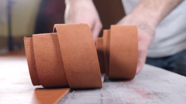 Manually cutting leather during craft manufacturing goods. Workshop of skinner, close-up shot showing hands of master and production process. Cutting of detail of leather accessories and bags on a — Stok video