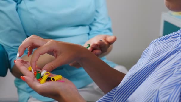 Braces on teeth. Close-up shot of female teenage choosing color of rubber bands for braces. White and healthy teeth. orthodontic therapy and treatment in modern dental clinic. 4 k footage — Αρχείο Βίντεο