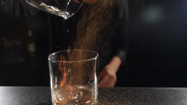 Повільне відео про коктейль барменів, що посипає корицю над полум'яним напоєм. Бармен п'є порошок кориці до полум'я коктейлю самбука, полум'яний коктейль, алкогольний напій, бар-вечірку. Повний HD — стокове відео