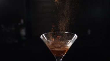 Slow motion cocktiail video of barmaid sprinkling cinnamon over flaming beverage. Bartender pours cinnamon powder to flame of sambuca cocktail, flaming cocktail, alcohol drink, bar party. Full hd