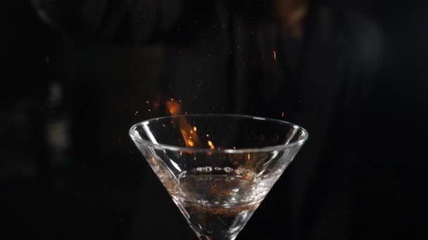 Video di cocktail al rallentatore di una cameriera che spruzza cannella su una bevanda fiammeggiante. Il barista versa la polvere di cannella a fiamma di cocktail di sambuca, cocktail fiammeggiante, bevanda alcolica, festa al bar. hd completo — Video Stock