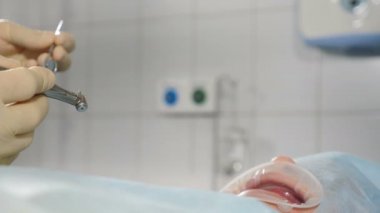 Diş Kliniği. Diş hekimliği, tıbbi cihazlar, diş tedavisi, dişçi. Dişçi eli matkapla su sıçratarak dişçi matkabının cerrahi operasyonunu gösteriyor. 4 bin.