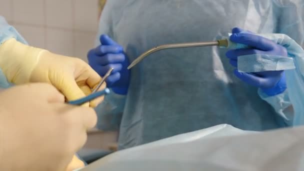 Dental health concept. Serious surgery in dental clinic. Surgeon implants dentures to patient. Close-up shot of oral dental surgery. Dentist and assistant during teamwork. 4 k video — 图库视频影像