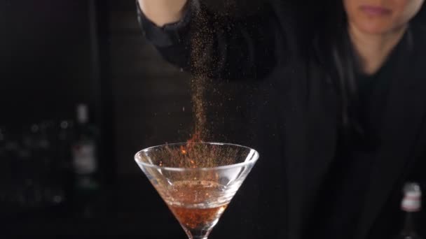 Бармен підпалює коктейль, спалюючи корицю в алкогольному напої на чорному тлі. Полум'я в коктейльному келиху при повільному русі, горіння кориці в алкогольному напої, бармен робить напій. Повний HD кадри — стокове відео