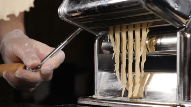 Nudlar eller Spaghetti gör maskinen. Långsam motion mat bilder av Fresh spaghetti pasta som kommer ut från pasta maskin, närbild. Chef använda pasta skärmaskin, Full hd — Stockvideo