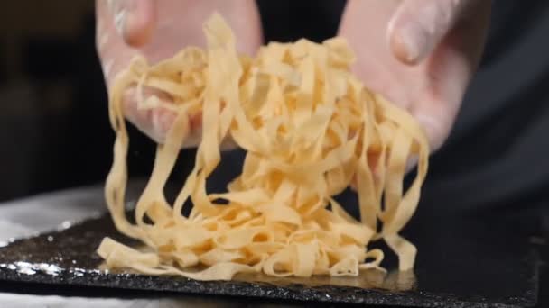 Chef holding in hands raw pasta. Making homemade fresh pasta. traditional italian recipe. Cooking food of italian cuisine. spaghetti pasta with flour in restaurant kitchen shot in slow motion. Full hd — Stock Video