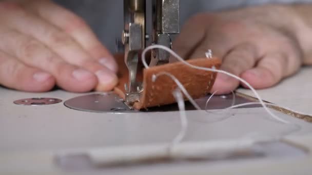 Máquina de coser de trabajo en artesanía de cuero privado, correa de costura en proceso. Sastre en el trabajo. Cinturón de costura de cuero masculino en taller de cuero. Macho artesano operando máquina de coser — Vídeos de Stock