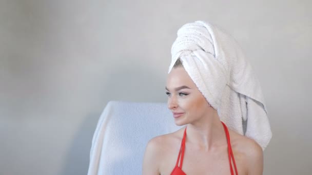 Elegancki portret radosnej, atrakcyjnej pół nagiej kobiety z ręcznikiem owiniętym wokół głowy, patrzącej w kamerę i uśmiechniętej. Odbiór. Materiał 4 k — Wideo stockowe