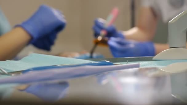 Tratamiento borroso dental inyectado a través de herramientas en la mesa. Dentista y enfermera en el trabajo, de cerca. Paciente sometido a cirugía médica y tratamiento de la cavidad oral en odontología moderna. 4 k vídeo — Vídeos de Stock