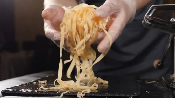 Male chef holding fresh selfmade pasta in slow motion. Chef showing pasta cooking homemade after pressing mixing flour with egg and ingredients. Full hd — Stock Video