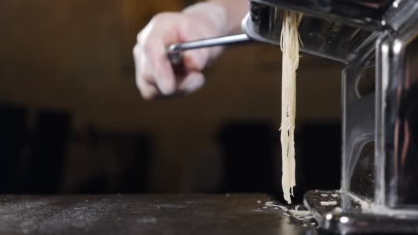 Vidéo sur la nourriture au ralenti. Faire des spaghettis de nouilles dans la machine à pâtes à main. Pâtes spaghetti fraîches sortant du gros plan de la machine. style cuisine maison. Full hd — Video