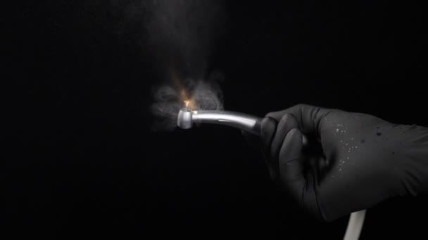 Équipement pour la dentisterie, les dispositifs médicaux, les outils, le traitement dentaire. Mains de dentiste en gants noirs avec perceuse illustrant le fonctionnement chirurgical de la perceuse dentiste avec éclaboussures d'eau — Video