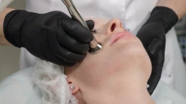 Side view on Young pretty woman getting cosmetology procedure in beauty salon. Hardware cosmetology. Anti-aging and anti-wrinkle apparatus cosmetology. Modern relaxing treatment. 4 k footage