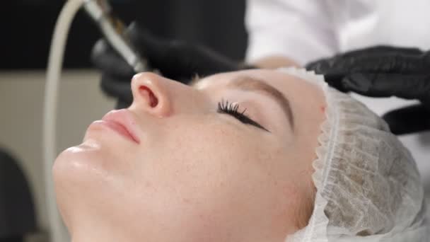 Mujer atractiva joven recibiendo procedimiento de cosmetología en el salón de belleza. Cosmetología de hardware. Cosmetología de aparatos antienvejecimiento y antiarrugas. Moderno tratamiento relajante. 4 k imágenes — Vídeo de stock