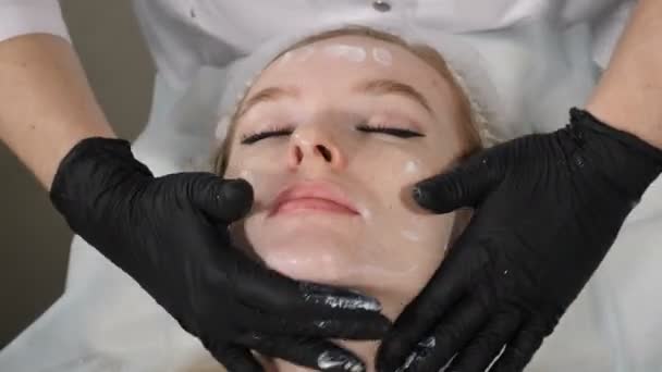 年轻女人要做面部按摩放松，温泉皮肤和身体护理。在温泉中心手工雕刻面部按摩以防止面部模仿皱纹。治疗师手部按摩脸部 — 图库视频影像
