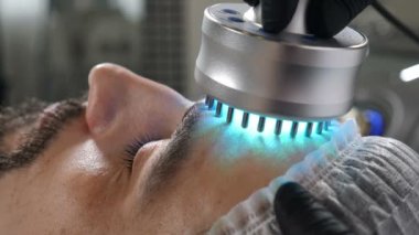 Güzellik salonunda kozmetik dersi alan yakışıklı bir adam. Donanım kozmetolojisi. Yaşlanma önleyici ve kırışıklık önleyici kozmetoloji. Modern rahatlatıcı tedavi. 4k görüntü