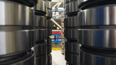 Endüstriyel üretim. Endüstriyel taşıyıcı fabrikanın içindeki ekipman ve devasa makine birimleri hazır bilyelerle birbiri ardına yığılmış. Depoda yeni parçalar ayır