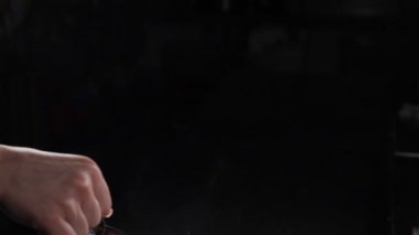 Alevler alev alıyor ve yemek pişirirken siyah arka planda yanıyor. Yavaş çekim. Siyah üzerine izole edilmiş gerçek ateş. Alevli yemek pişirmek. Restoranın mutfağında ateş açın. Konyak ateşlenir. Tam Hd