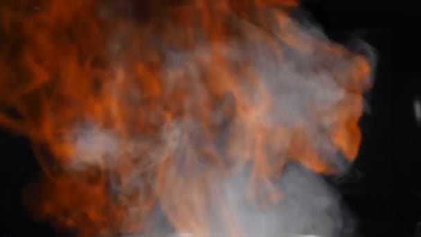 Flammes de feu allumant et brûlant sur fond noir pendant la cuisson. Des images au ralenti. Véritable incendie isolé sur noir. Cuisson plat de flamme. Feu ouvert au restaurant cuisine. Le cognac est enflammé. Full hd 