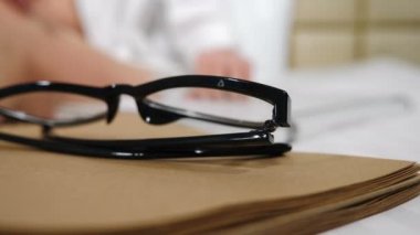 Beyaz dizüstü bilgisayar klavyesinde yazan bulanık elleri olan bir kadın. Kapatın. Odak noktasında siyah gözlüklerden vurulmuş. Yaratıcı ve serbest çalışan konsepti. 4K 'da çekilmiş.