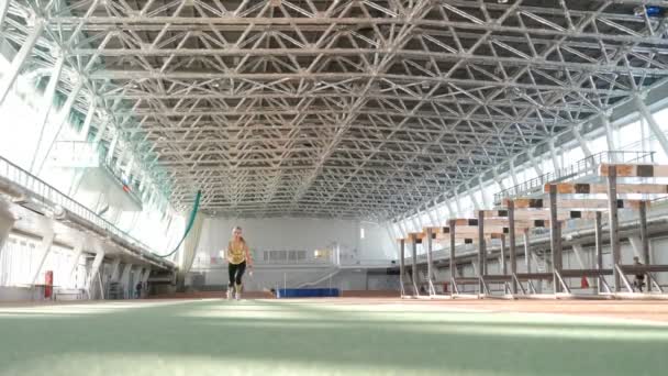 Läuferinnen trainieren Joggen auf einer professionellen überdachten Arena. Fitness Frau Rennen im Stadion, Sport Leistungskonzept. Blonde Sportlerin beim Lauftraining im Sportstadion. Volle Konzentration — Stockvideo