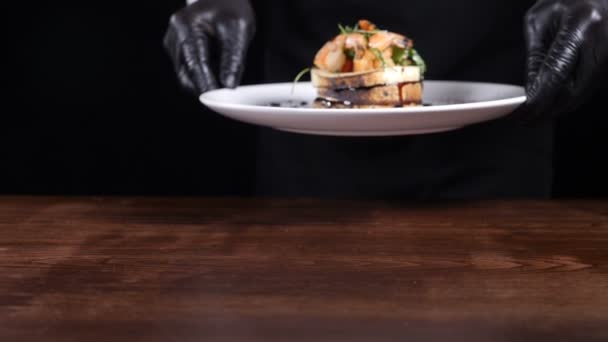Крупним планом чоловічий шеф-кухар представляє страву з салатом з моцарелли на білій тарілці. Кухня в ресторані. Повільне відео руху. Повний HD — стокове відео