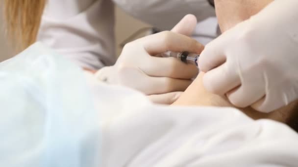 Жінка-лікар дерматолог косметолог проводить ін'єкції ботулінового токсину для омолодження шиї в сучасній клініці краси. Повний HD — стокове відео