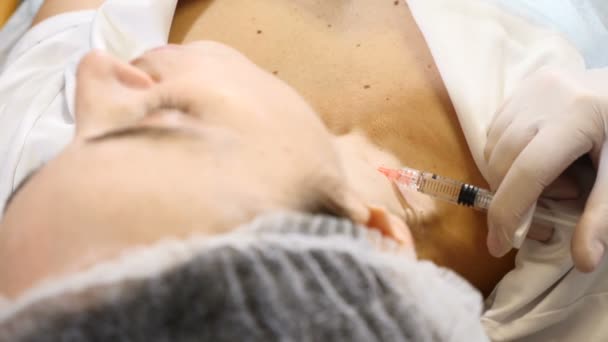 La doctora dermatóloga cosmetóloga realiza inyecciones de toxina botulínica para el rejuvenecimiento del cuello en una clínica de belleza moderna. Full hd — Vídeo de stock