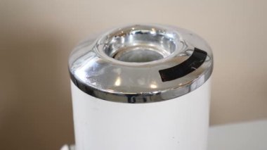 Tıbbi aletlerin dezenfeksiyon ve sterilizasyonu, güzellik stüdyosu veya ilaç aletleri için ekipman. Kadın elinin beyaz, yuvarlak sterilizatörün içine makas koyduğu yakın plan. Kozmetik aletleri temizliği. Tam