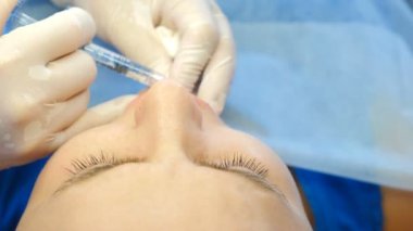 Dudak enjeksiyonu estetik cerrahi. Dudak büyütme ameliyatında kadın hasta yüzünün yakın görüntüsü. Güzellik kliniği. Güzellik uzmanı kadın dudaklarına botoks yapıyor. Genç kadın yüz enjeksiyonu yaptırıyor.