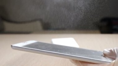 İşlem, temizlik ve sterilizasyon konsepti. Virüs ve bakterilere karşı tablet yüzey dezenfeksiyonu. Koruyucu eldivenli kadın elinin, hücre temizlemek için ıslak mendil ve dezenfektanla yakın plan fotoğrafı.