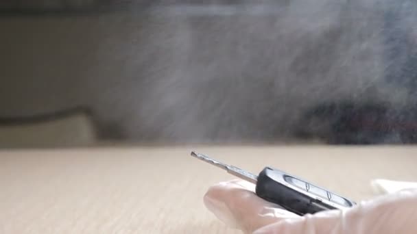 La mano femenina sostiene la llave del coche y la desinfecta con un aerosol desinfectante a base de alcohol. Medidas de protección contra el coronavirus y el peligro pandémico. Concepto de limpieza y desinfección. 4 k imágenes — Vídeos de Stock