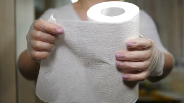 Неузнаваемая женщина отрывает бумажное полотенце с рулона. Кухонные принадлежности. Женские руки берут кусок белого кухонного полотенца. Концепция обработки, очистки и стерилизации. 4 тысячи выстрелов — стоковое видео