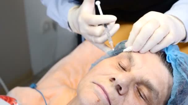 Närbild skott av kosmetolog applicera anestesi injektion med spruta till senior kvinnlig klient. kvinna i 70-årsåldern gör sig redo för skönhetsbehandling på hälsokliniken. 4k-bilder — Stockvideo